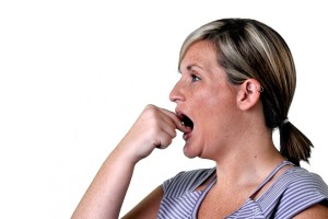 Woman with her hand to her mouth, appearing surprised or in shock.