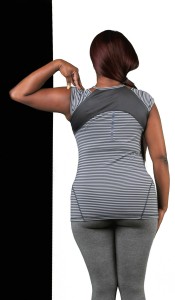 The image features a woman from behind, wearing a sleeveless top with a striped pattern and grey leggings. She has her left hand on her hip and is standing against a white background with a black border at the bottom.