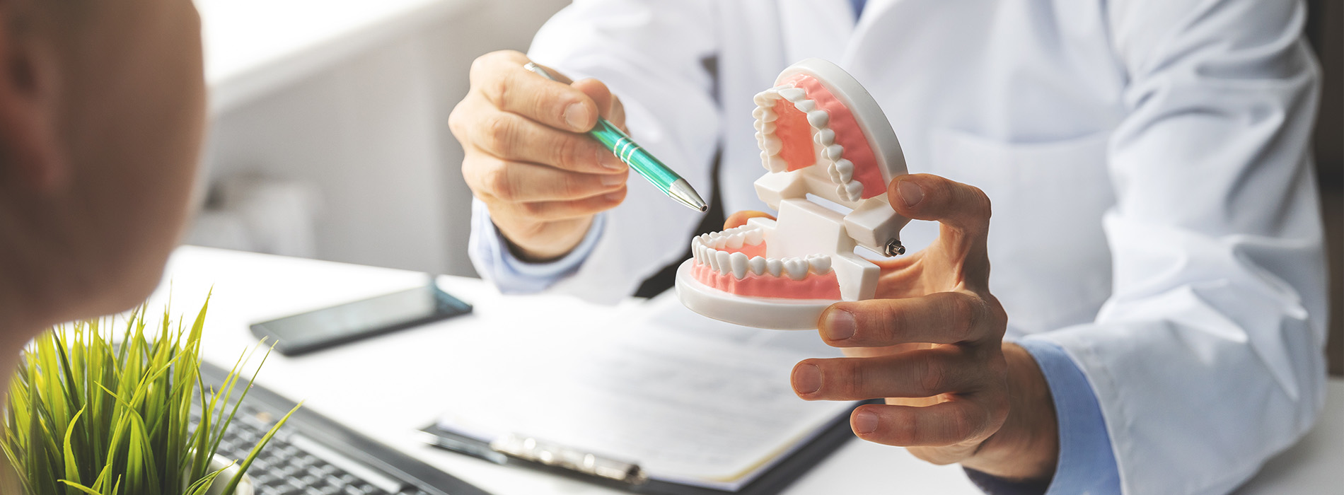 A dentist examining a patient s teeth with a dental mirror and probe, set in a professional office environment.