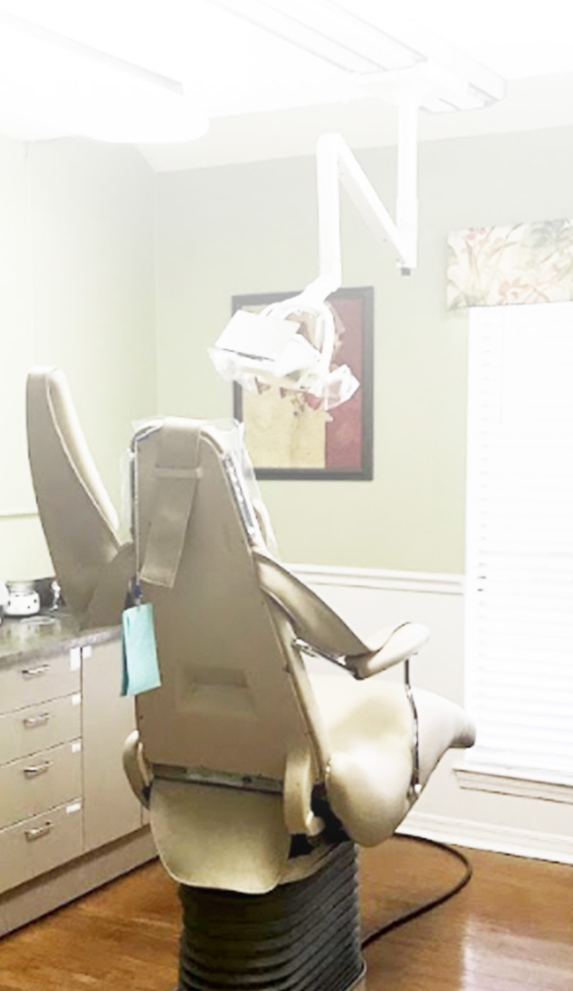 The image shows a modern dental or medical office interior with a dental chair, equipment, and a clean, professional environment.